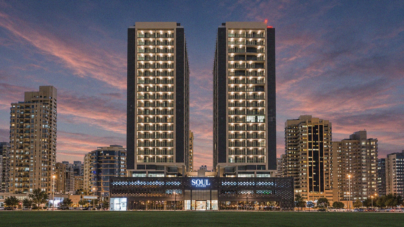 Soul Avenue's two residential towers illuminated at dusk in Al Mamzar, Dubai